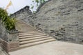 Stone stairway along aged grey brick wall