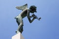 Stone statue of an angel playing music in a wind instrument