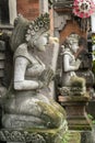 Stone statue with hands in a praying atthe temple' entrance on Bali, Indonesia