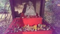 Praying monk statue with autumn leaves