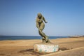 Stone statue of a runner standing on the seashore of Dakar, Senegal, Africa. It is a beautiful long beach and in the background