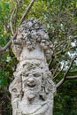 Stone statue of smiley man with a basket of fruits on the top of his head Royalty Free Stock Photo