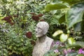 PhotographerStone Statue Surrounded by Beautiful Flowers in a Garden Royalty Free Stock Photo