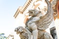 Stone statue of a winged wolf at the entrance of a palace