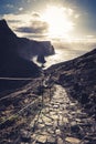 Stone steps in a rough rocky cliff landscape on a hiking trail going Down to the sea during sunset Royalty Free Stock Photo