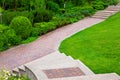 Stone steps to a path from paving slabs in a park on a slope. Royalty Free Stock Photo