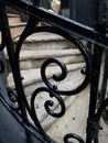 Stone steps visible through decorative intricate iron railing Royalty Free Stock Photo