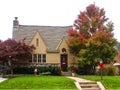 Stone and stucco cottage with autumn leaves a Japanese maple and Christmas bows and wreaths Royalty Free Stock Photo