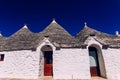 Stone tiles cover the roofs of the trulli in Alberobello, an Italian city to visit on a trip to Italy