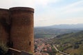 Stone tower and green hills with rooftops near Orvieto