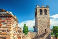 Stone tower with merlons on top and brick wall of old medieval castle Castello di Desenzano del Garda Royalty Free Stock Photo