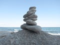 Harmony, balance and simplicity concept. A stone tower on the sea background. Simple poise pebbles, rock zen sculpture Royalty Free Stock Photo