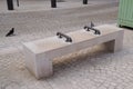 Stone town bench seat with center arm steel rests on hostile design prevents for people homeless from laying down in city center Royalty Free Stock Photo