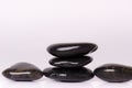 Stone treatment. Black massaging stones on a white background. Hot stones. Balance. Zen like concepts. Basalt stones.