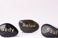 Stone treatment. Black massaging stones on a white background. Hot stones. Balance. Zen like concepts. Basalt stones.