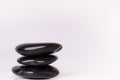 Stone treatment. Black massaging stones on a white background. Hot stones. Balance. Zen like concepts. Basalt stones.