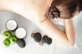 Stone treatment. Top view of beautiful young woman lying on front with spa stones on her back. Beauty treatment concept. Royalty Free Stock Photo