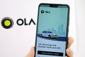 Ola cabs app login screen on the smartphone an the company logo on the blurred background. Ola Cabs.is a ride sharing company