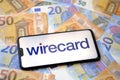Wirecard logo on smartphone and euro banknotes on the blurred background Royalty Free Stock Photo