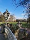 Stone vases of the Elaginoostrovsky Palace with flower beds and a beautiful fence against the background of leafless trees,