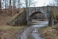 Stone viaduct over the old railway track. A dirt road leading under an old railway bridge Royalty Free Stock Photo