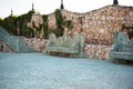 Stone walkway. Alley in beautiful garden with stone benches, flight of stairs, flowers and trees around. Summer in the garden Royalty Free Stock Photo