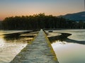 stone walkway over the sea with forest at sunset in Las Rias Bajas of Galicia