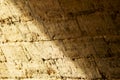 Stone wall at an angle close-up. Sunlight falls on the wall. Half of the wall is in the shade. Royalty Free Stock Photo