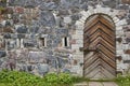 Stone wall with antique castle locked wooden door. Vintage