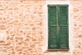 Stone wall background with old green wooden window shutters