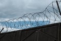 Stone wall with barbed wire against blue sky Royalty Free Stock Photo