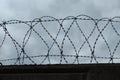Stone wall with barbed wire against blue sky Royalty Free Stock Photo