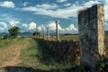 A stone wall with a barbed wire fence in the foreground Royalty Free Stock Photo