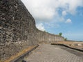 Stone wall with brick path under blue sky Royalty Free Stock Photo