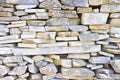 Stone wall built with blocks and marble slabs simply placed over