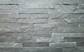 Stone wall cladding made of horizontal gray bricks of natural rock stacked . Royalty Free Stock Photo