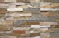 Stone wall cladding made of natural strip rocks. Colors are pink,white,brown,gray.