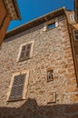 Stone wall with closed windows and gargoyle in niche at Les Arcs-sur-Argens. Royalty Free Stock Photo