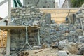 Stone wall during construction and masonry tools Royalty Free Stock Photo