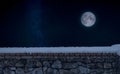 Stone wall covered by snow with a nignt sky background Royalty Free Stock Photo