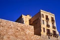 Stone wall and historic building with shutters and balconies in the town of Chania on the island of Crete Royalty Free Stock Photo