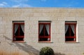 Stone wall of the house with three windows Royalty Free Stock Photo