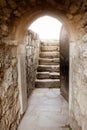 Stone wall with open door and rays of light behind