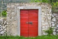 Stone wall with a red wooden door Royalty Free Stock Photo