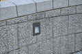 Stone wall of regular granite roughly hewn blocks with a hidden lamp to the wall surface. it shines under the feet of pedestrians