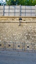 Stone wall by a road with railings and green plants Royalty Free Stock Photo