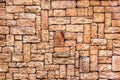 Stone wall seamless texture close-up. Bright brown rock tile texture. Tile faceted stone wall background for design.
