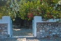 Stone wall in a shade of trees around an old greek house at Panormos beach, island of Skopelos