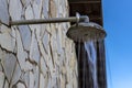 Stone wall with shower with falling water, outdoors in a swimming pool Royalty Free Stock Photo