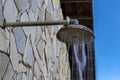 Stone wall with shower with falling water, outdoors in a swimming pool Royalty Free Stock Photo